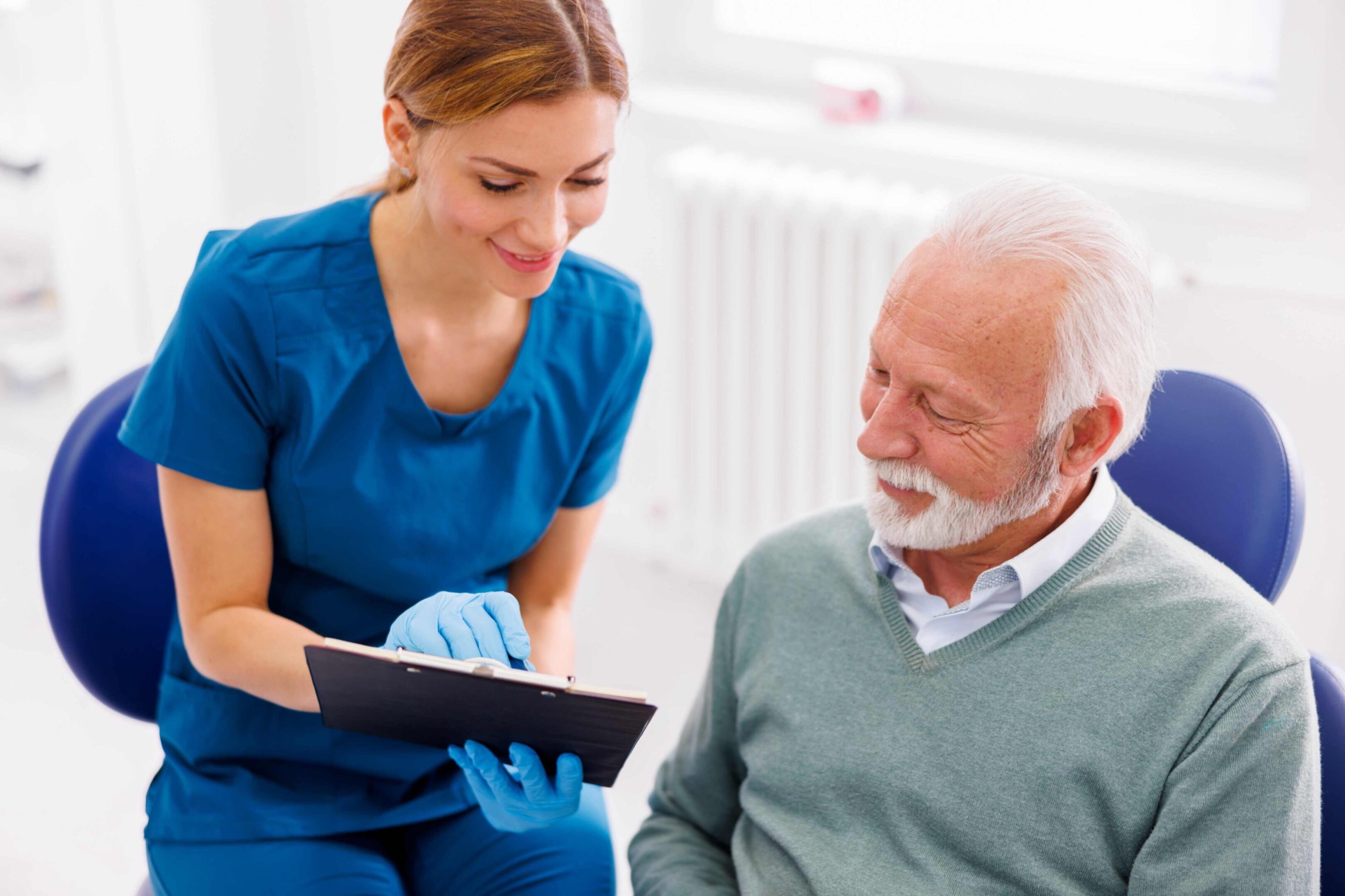 Nurse showing clipboard to senior patient.