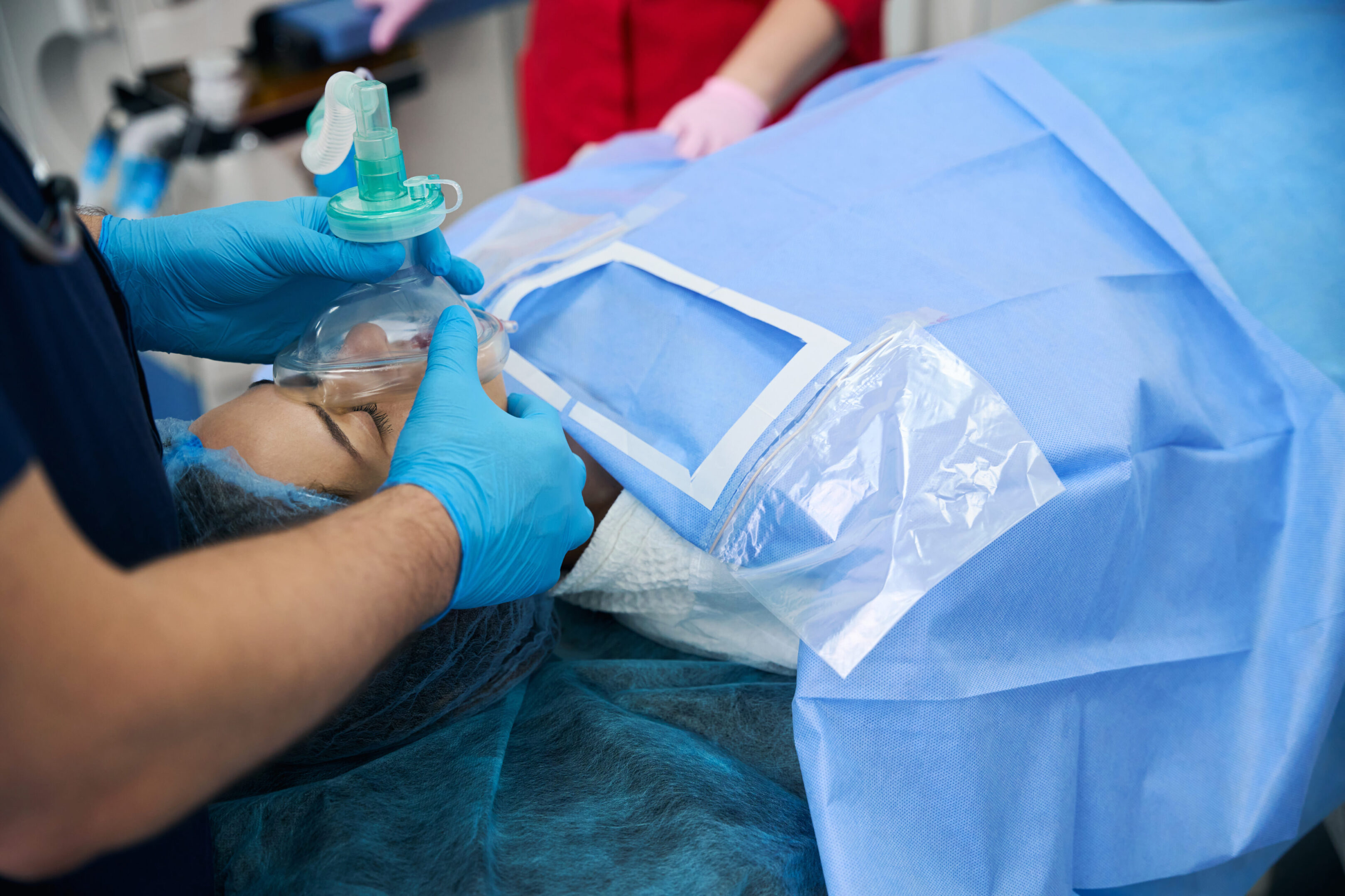 Patient under anesthesia on the operating table, with experienced medical staff nearby