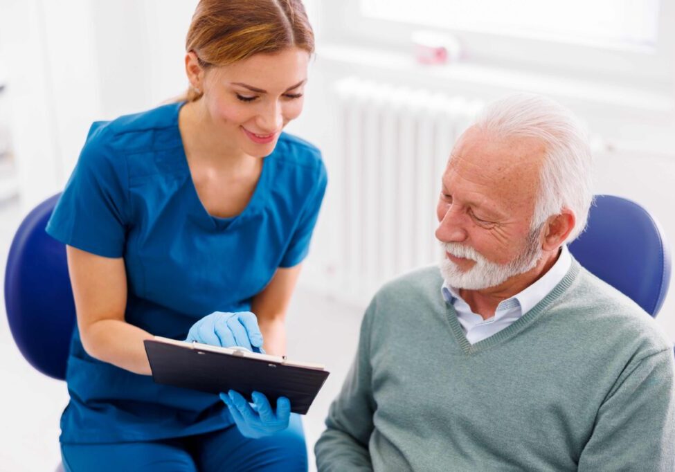 Nurse showing clipboard to senior patient.